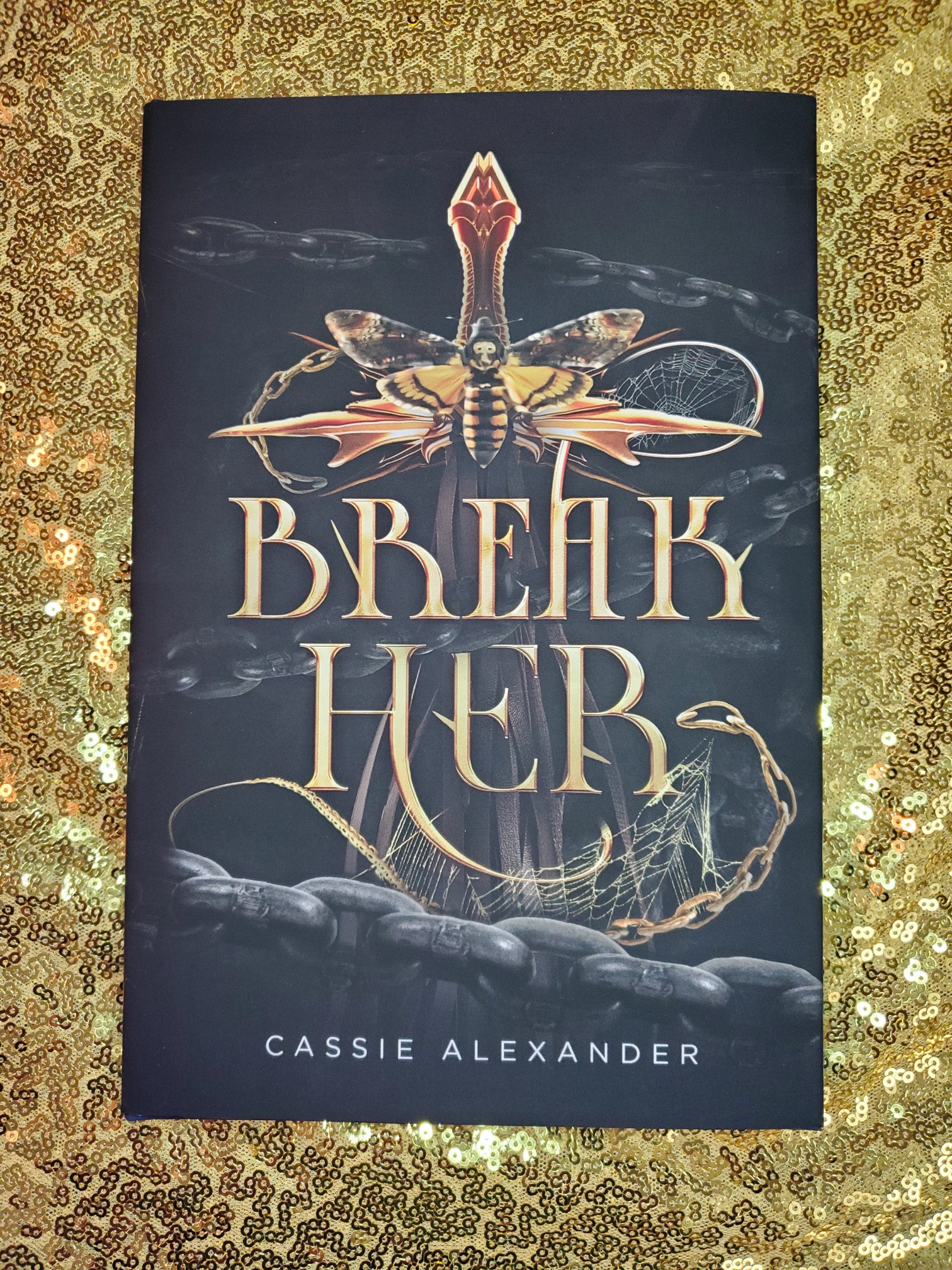 Hardcover of Break Her by Cassie Alexander on a gold sequined background.