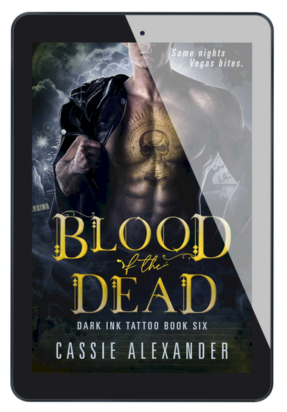 Cover for Blood of the Dead: Dark Ink Tattoo Book Six by Cassie Alexander. A man wearing a black leather jacket over one shoulder with a yellow skull and circular tattoo on his chest stands in front of a Las Vegas skyline. Tagline reads: Some nights Vegas bites. Shown as an ebook on a tablet..